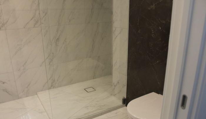 Grandi piastrelle di marmo nel bagno combinato