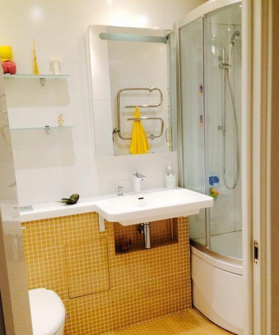Design del bagno bianco e giallo con doccia