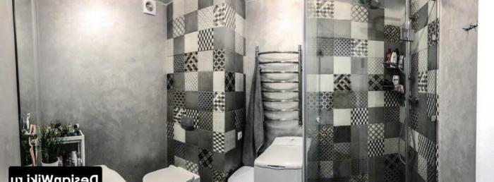 La combinazione di piastrelle grigie e intonaco decorativo in bagno