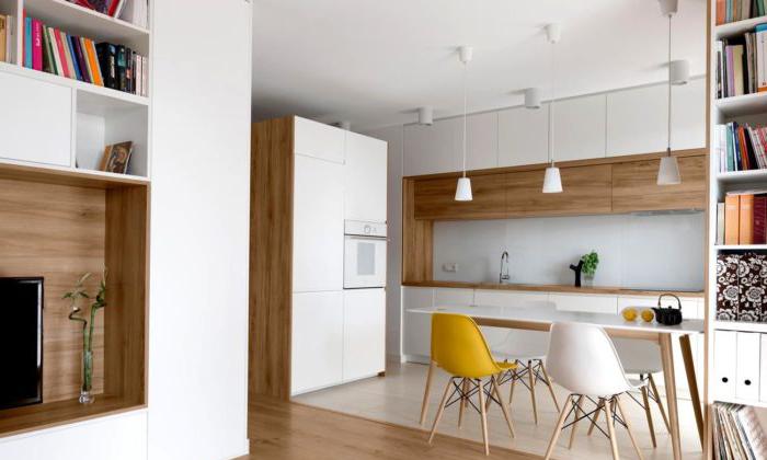 Cucina bianca con piano di lavoro in legno e cassetti sul soffitto