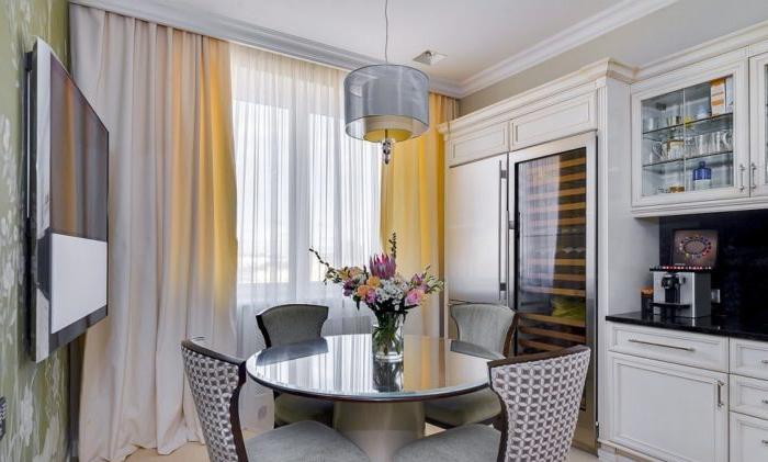 Tende beige all'interno della cucina con una porta del balcone nello stile di un classico moderno